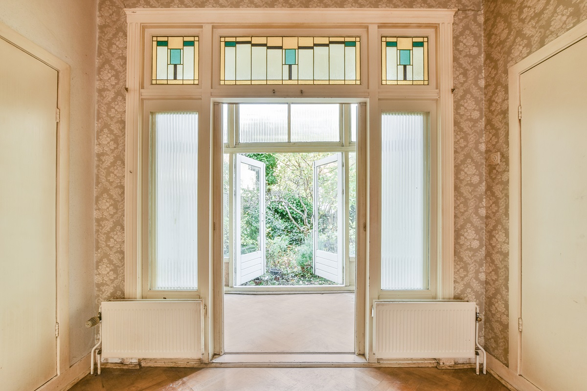 Opened white windows in front of the entrance door to the room